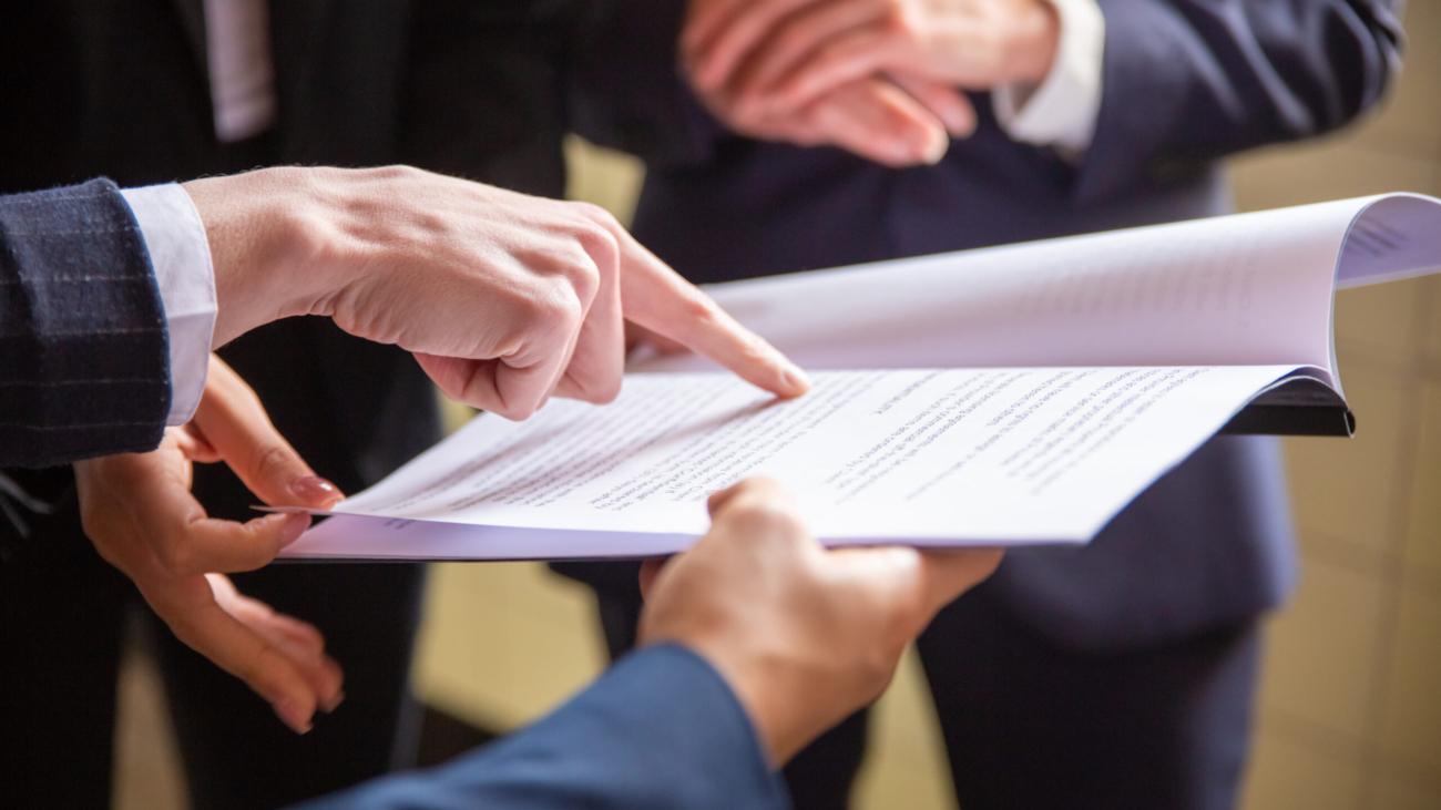 Cropped view of businesswomen reading document. Closeup shot of female finger pointing at page. Business concept