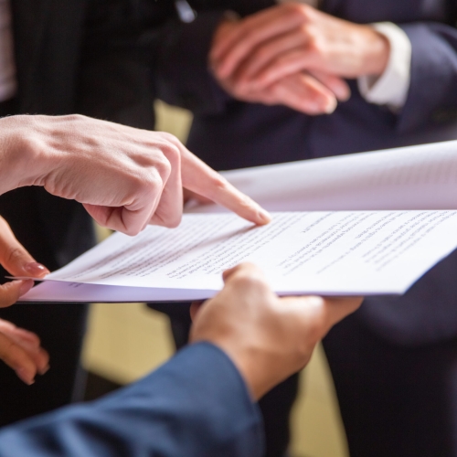 Cropped view of businesswomen reading document. Closeup shot of female finger pointing at page. Business concept